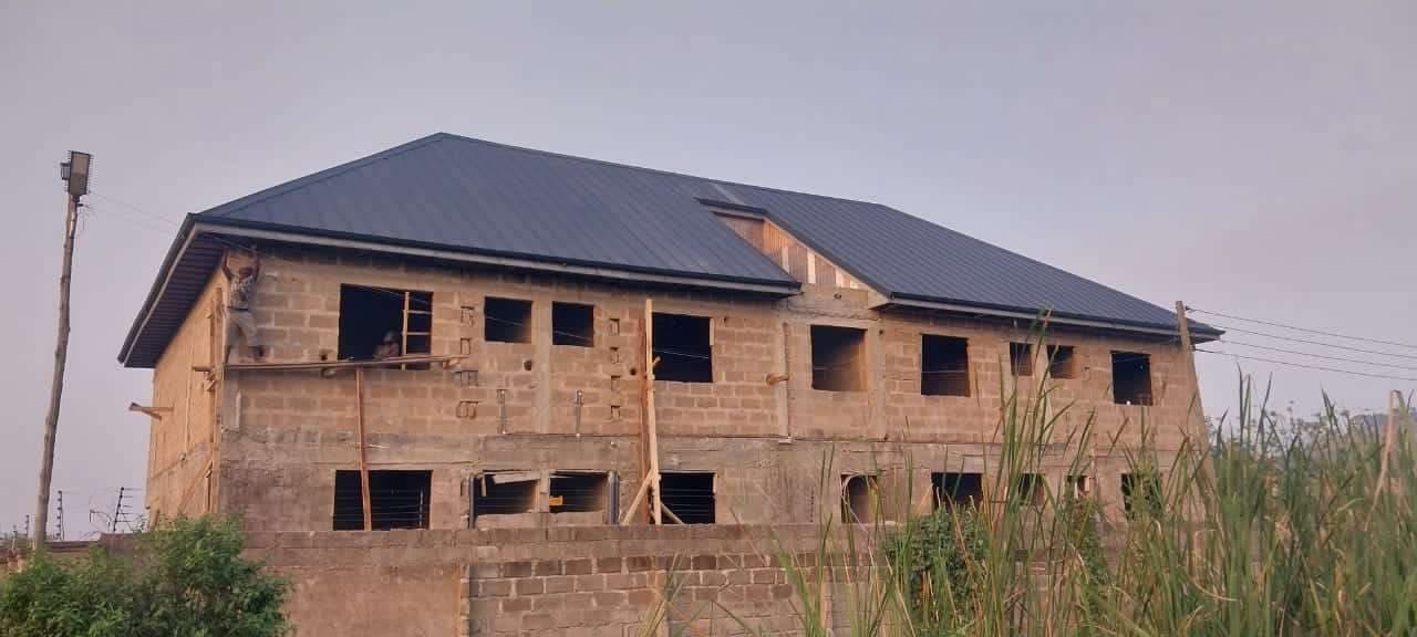 Completed dark metal roof on a two-storey building